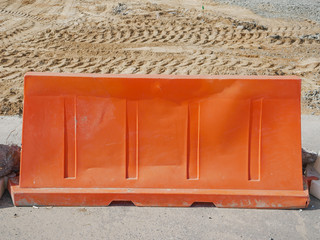 Noyabrsk, Russia - August 9, 2020:  An orange plastic road block stands on a concrete road to restrict traffic and road works.