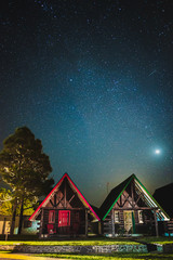 Beautiful wood cabins below a sky full of stars