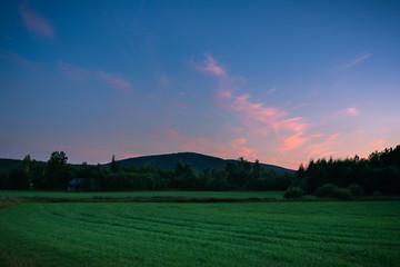 Beautiful sunset over field and moutain.