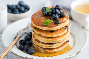 Stack of pancakes with blueberries and maple syrup. Closeup view. Tasty american pancakes