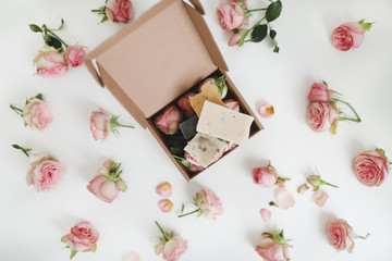 Natural homemade organic soap with pink roses and petals on white background. Spa concept, top view, flatlay 