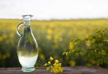 Rape oil and flower on wooden table. Speca for copy, text