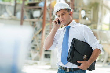 mature engineer talking on the phone outdoors