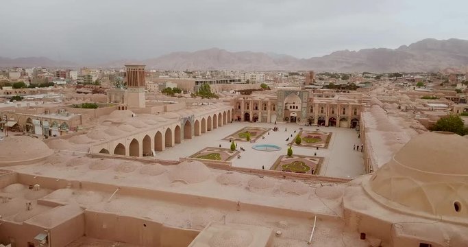 Old mosque dome in Kerman Old city in Iran and historical ventilation windcacher building structure architecture and mountains in background landscape