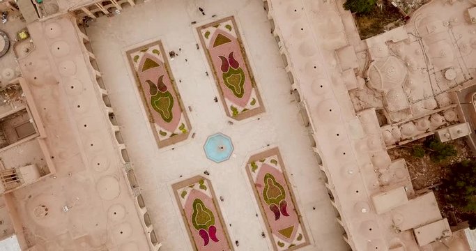 Iran Kerman city Ganjali khan complex yard with historical mud brick Vakil mosque dome, Bazaar and cityscape design with gardening flower in Spring season in daytime