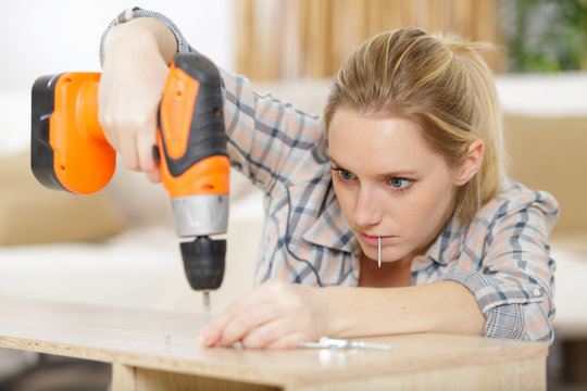 young woman using electric screwdriver