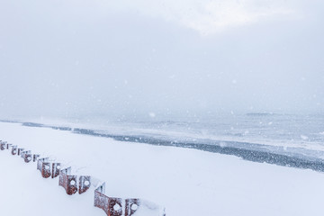 Snowing on the beach with a rough sea in the background.Snowy conitions by the sea in TAdzikidziri beach, Batumi, Sakartvelo.