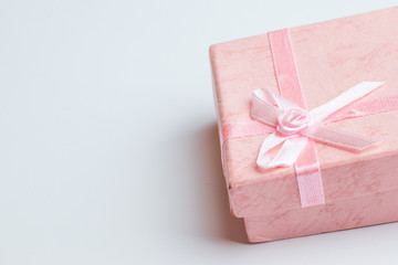 Pink box with present on white background. Copy space