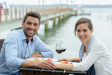 cute couple drinking near the sea