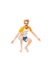 Excited man in flip flops and sunglasses jumping isolated on white