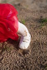 little child's foot in white tights stands on  yellow sand, dirt and sand on clothes