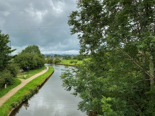 Fototapeta premium View over the Leeds to Liverpool canal, with houses and trees in the distance in, Skipton, Yorkshire, UK