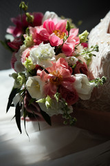 bouquet with pink and white flowers in  dark room, deep shadows, selective focus