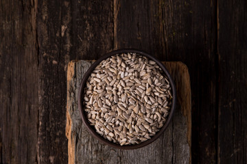 Peeled sunflower seeds in a bowl, on a wooden background. top view, rustic style