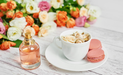 Bouquet of flowers on table. Cup of tea or coffee and macaroons. Greeting card for mothers day. Happy Birthday. Romantic breakfast. Flowers composition for Valentine. Cosmetics perfume.