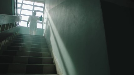 This video shows a man in protective overalls sanitizing and disinfecting a disinfectant solution all over the passage.