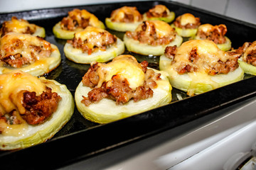 Baked zucchini on a baking sheet cut into rings, fill with minced meat and cheese.