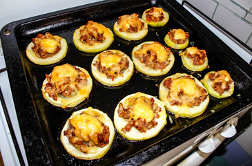 Baked zucchini on a baking sheet cut into rings, fill with minced meat and cheese.