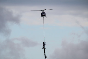 Ein Lasten Hubschrauber beim Transport von einem Masten.