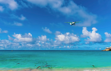 Fototapeta na wymiar An airplane approaches the airport over Maho Beach in St Maarten