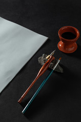 Calligraphy master work table with paper and pen