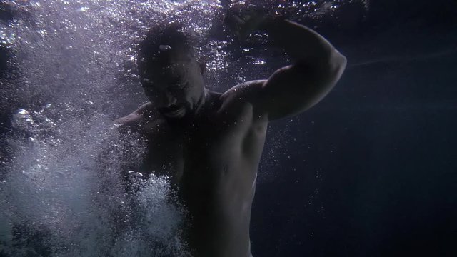 angry black man is striking water, fighting in depth