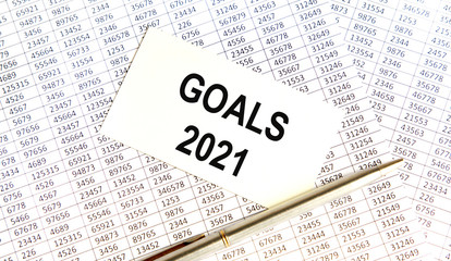 Obraz premium GOALS 2021 words written on a white piece of paper laid on a wooden table. Top view, concept in business.