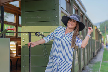 Tourism and travel in the summer. Vacations for business woman. Caucasian young woman on platform of the railway station