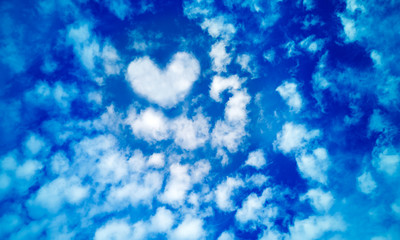 Fototapeta na wymiar Blue summer sky of white cirrus,cumulus and layered air clouds,with heart shaped cloud in middle,on beautiful day.Banner,texture or abstract background for text, blog,design,card,website,pattern,model
