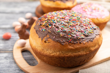 Homemade glazed and decorated easter pies on a gray wooden background and linen textile. Side view, selective focus.