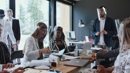 Safety measures at workplace against COVID-19. Multiethnic business people team wearing face...