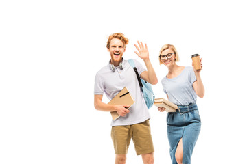 Fototapeta premium Students with books and coffee to go waving hand at camera isolated on white