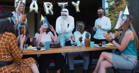 Fun COVID-19 birthday party. Young Caucasian woman sharing crazy fun celebration with friends and confetti slow motion.