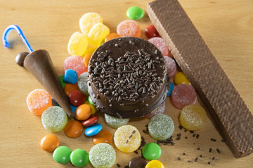 Different sweets on a table, chocolate, alfajores, gummies, sugar. Lots of sweets, junk food high in sugar. Food that raises blood glucose.