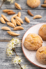 Almond cookies and a cup of coffee on a gray wooden background. Side view, selective focus.
