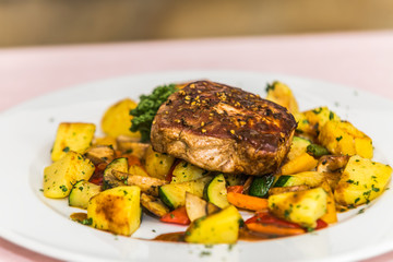 Juicy steak with potatoes and vegetables. The food in the restaurant. Food styling and restaurant meal serving.