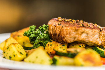 Juicy steak with potatoes and vegetables. The food in the restaurant. Food styling and restaurant meal serving.