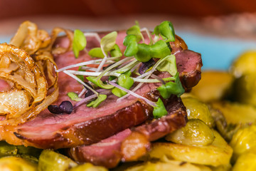 Slice of pork meat with fried onion and potatoes. The food in the restaurant. Food styling and restaurant meal serving.