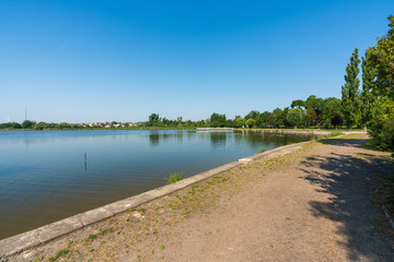 A small lake in the town of Żnin on a beautiful sunny day with a blue cloudless sky.