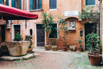 Small square in Venice Italy. Without people. Beautiful postcard from venice. Charming corners and places of Venice. Nice houses, plants and windows.