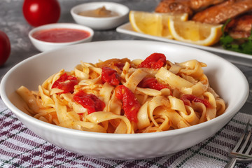 Pasta with tomatoes and grilled wings. Italian food. Italian Cuisine. The concept of tasty and healthy food.
