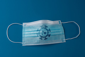 Surgical face mask with coronavirus print on blue background