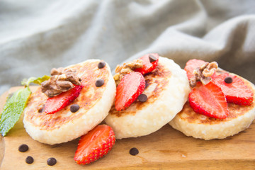 A healthy breakfast of pancakes, strawberries, chocolate, and honey