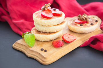 A healthy breakfast of pancakes, strawberries, chocolate, and honey