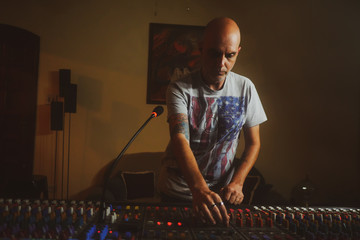 Fototapeta na wymiar Music producer controlling sound mixer in music studio