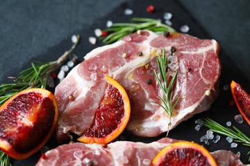 Raw meat steaks with rosemary and spices on a stone board. Keto. Paleo. Pegan diet.
