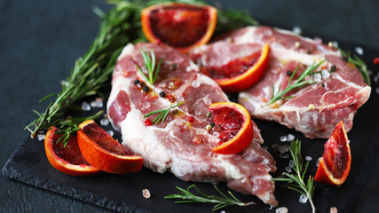 Raw meat steaks with rosemary and spices on a stone board. Keto. Paleo. Pegan diet.