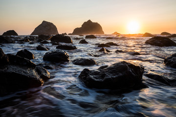 Beautiful sunset with splashing waves on the beach of False Klamath Cove in Redwood National Park...