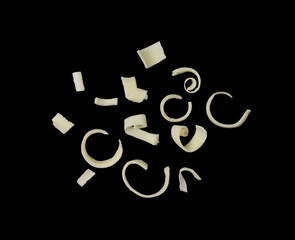 White Chocolate Curls Isolated On black Background. Group of chocolate shavings. Chocolate roll.