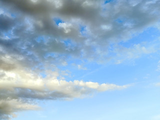 photo of blue sky with white and gray clouds on a summer evening